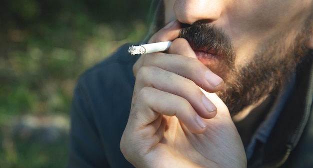 Homme fumant une cigarette. Notion de fumer