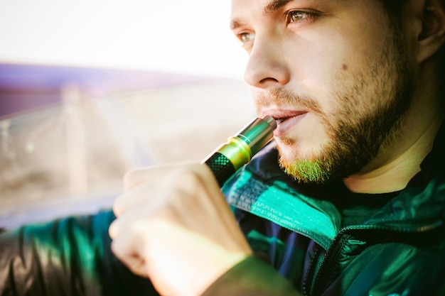 Photo un homme fume une cigarette électronique.