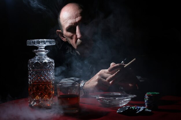 l'homme fume la pipe et joue au poker