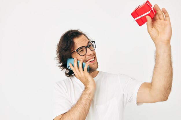 Homme gai boîte cadeau rouge communication téléphonique fond isolé