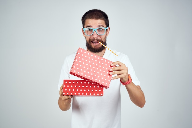 Homme gai avec un cadeau dans des verres surprise de mode de vie de vacances