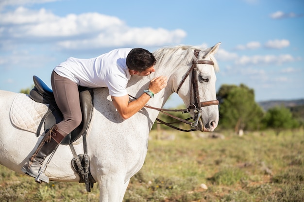 Homme gai à cheval et câlin cheval