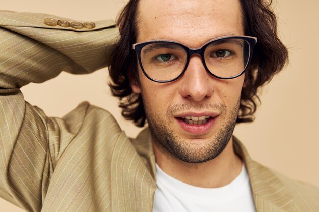 Homme gai en costume posant des émotions porter des lunettes fond beige