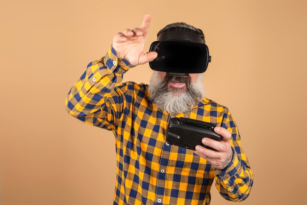 Un homme gai dans des lunettes 3D joue avec un joystick sur fond jaune