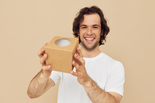 Homme gai dans un t-shirt blanc avec une boîte-cadeau