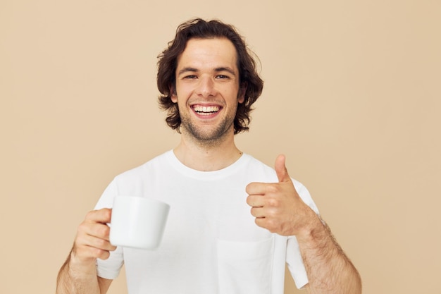 Homme gai dans un T-shirt blanc avec une tasse à la main