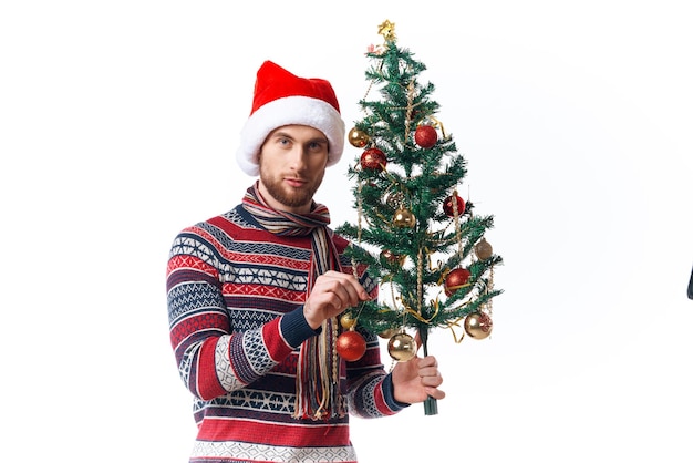 Homme gai dans les vêtements du Nouvel An décoration studio de Noël posant