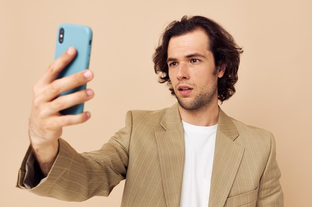 Un homme gai prend un arrière-plan isolé de technologies de style classique selfie. Photo de haute qualité