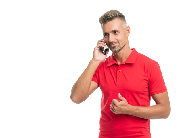 Homme gai en t-shirt rouge parlant sur smartphone isolé sur fond blanc pouce vers le haut