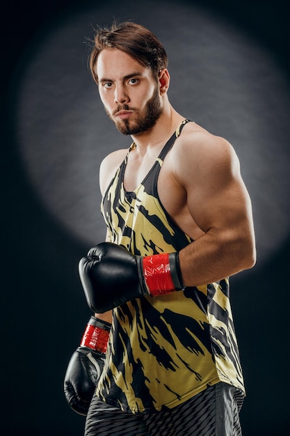 Un homme en gants de boxe Un homme boxe sur fond noir Le concept d'un mode de vie sain