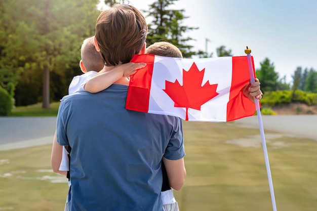 Un homme et un garçon tenant un drapeau canadien