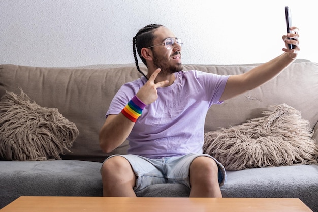 Homme gay prenant un selfie sur le canapé