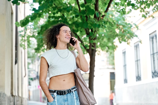 un homme gay qui marche et parle sur son téléphone intelligent