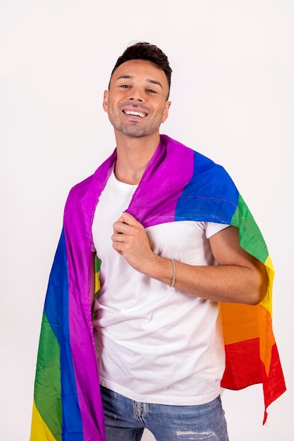 Homme gay souriant tenant le drapeau de la fierté