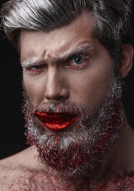 Homme glamour aux lèvres rouges et à la langue