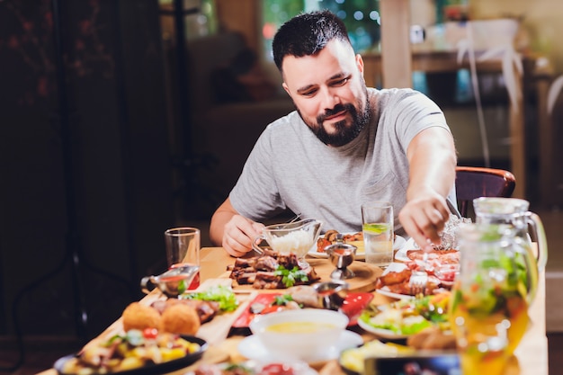 Homme à la grande table avec de la nourriture.