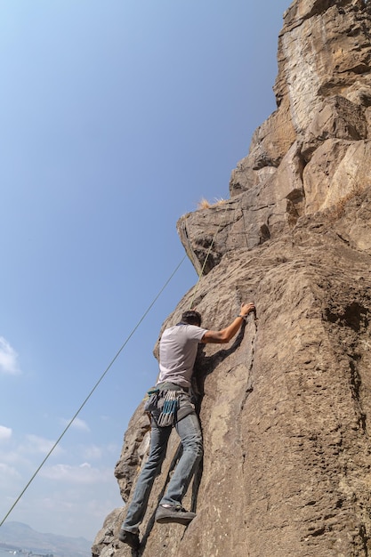 Homme grimpant sur un rocher impressionnant