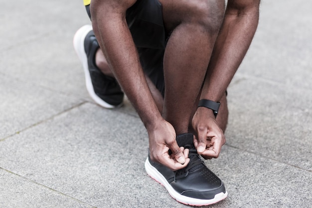 L'homme en gros plan attache les lacets des baskets avant de courir