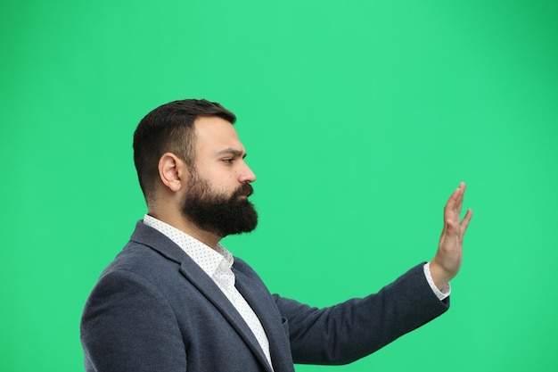 Un homme en gros plan sur un fond vert agitant sa main