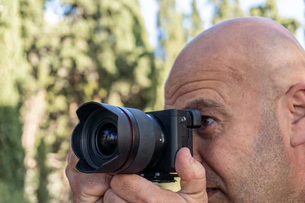 Photo un homme en gros plan prend des photos avec un appareil photo dslr à l'extérieur