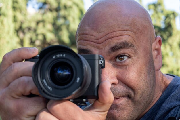 Photo un homme en gros plan prend des photos avec un appareil photo dslr à l'extérieur