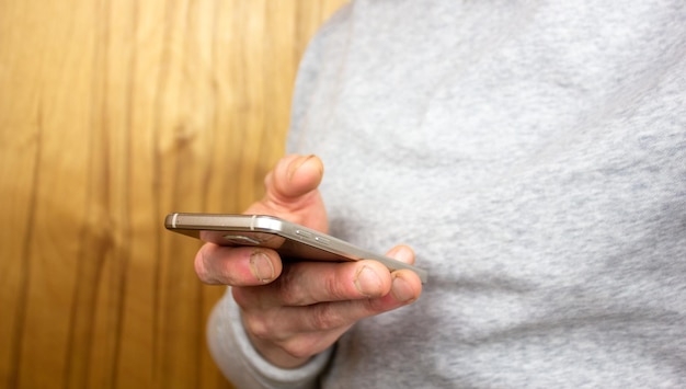 Un homme avec un gros plan de smartphone Un gars dans une veste légère utilise un smartphone