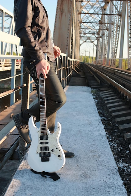 Homme avec une guitare sur un chemin de fer