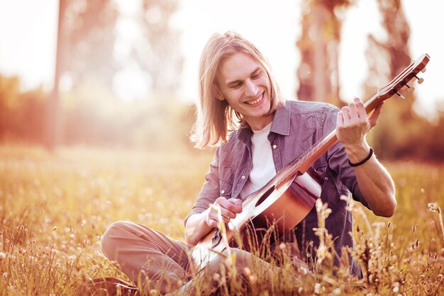 Homme avec guitare dans la nature