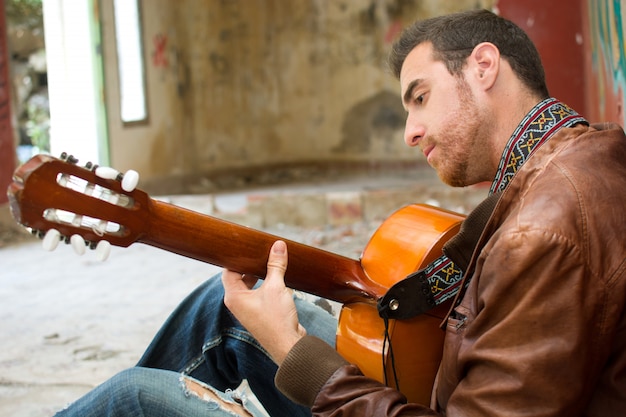 homme avec guitare dans un style urbain de bâtiment en ruine