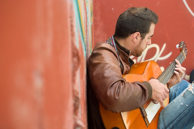 homme avec guitare dans un style urbain de bâtiment en ruine