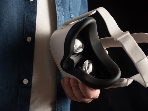 Homme habillé avec désinvolture tenant un casque de réalité virtuelle