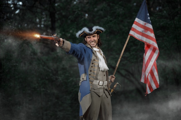 homme habillé en soldat de la guerre de la révolution américaine des États-Unis vise de pistolet avec drapeau
