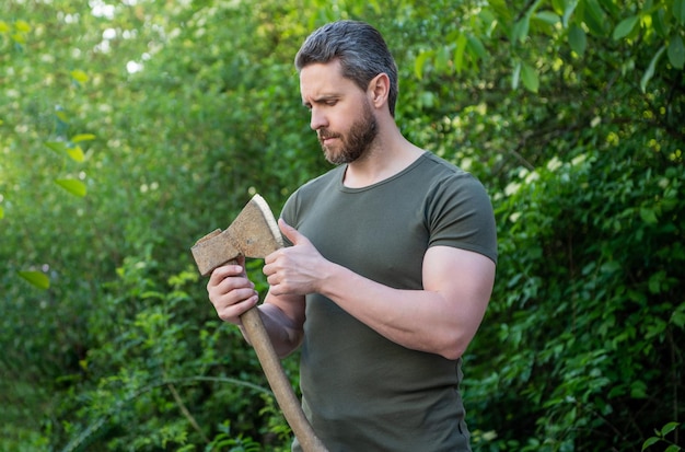 homme avec une hache portant une chemise masculinité homme avec une axe photo en plein air de l'homme avec une haxe homme avec la hache