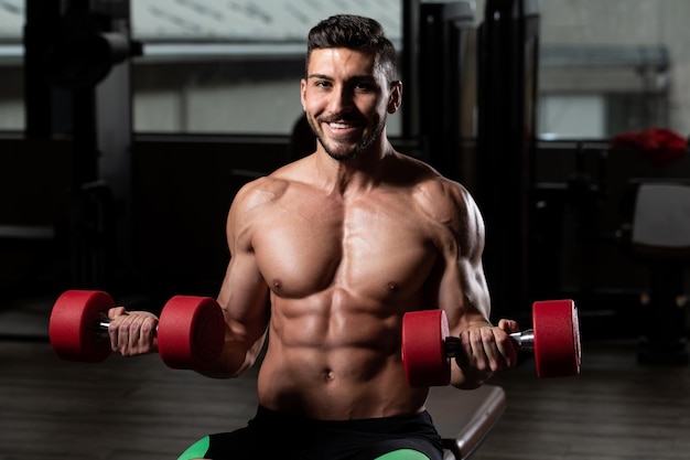 Homme avec des haltères exerçant des biceps