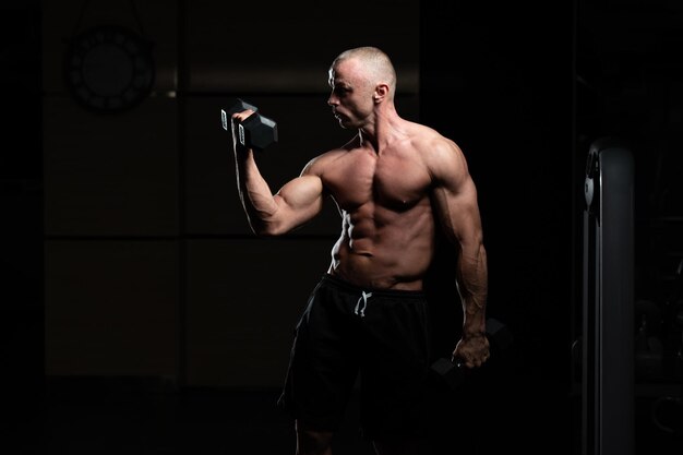 Homme avec des haltères exerçant des biceps