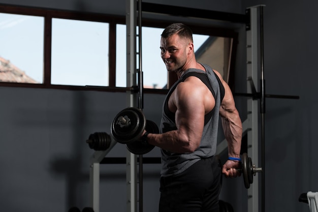 Homme avec des haltères exerçant des biceps