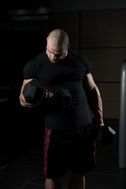 Homme avec des haltères exerçant des biceps