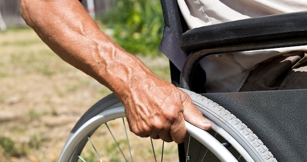 Photo homme handicapé assis dans un fauteuil roulant