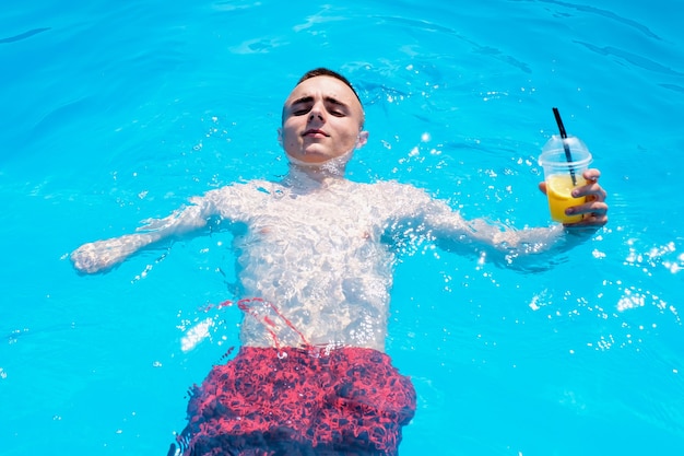 Homme handicapé avec cocktail au frais dans la piscine