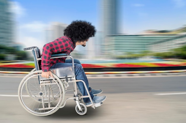 Un homme handicapé est assis dans un fauteuil roulant avec un mouvement rapide