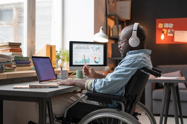 Homme handicapé étudiant à la maison