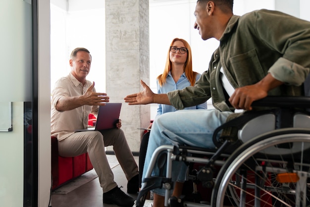 Photo homme handicapé en fauteuil roulant ayant un travail de bureau