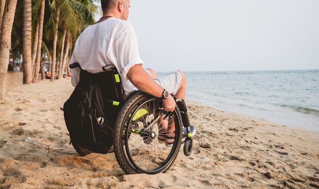 Homme Handicapé En Fauteuil Roulant Sur La Plage.