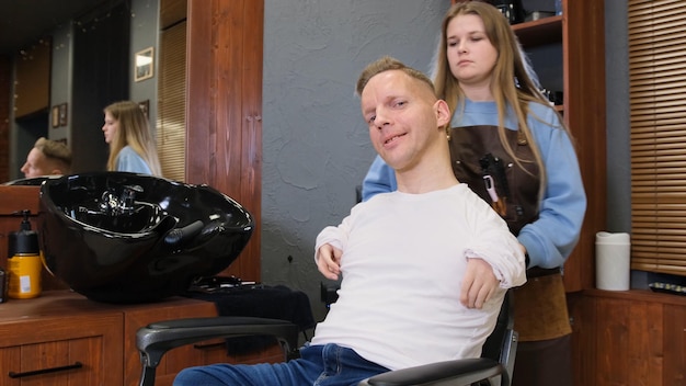 Un homme handicapé se fait couper les cheveux et coiffer dans un salon de coiffure