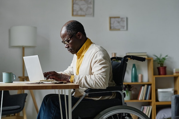 Homme handicapé tapant sur un ordinateur portable