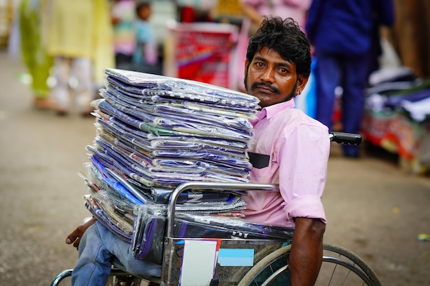 Homme handicapé vendant des vêtements sur le marché