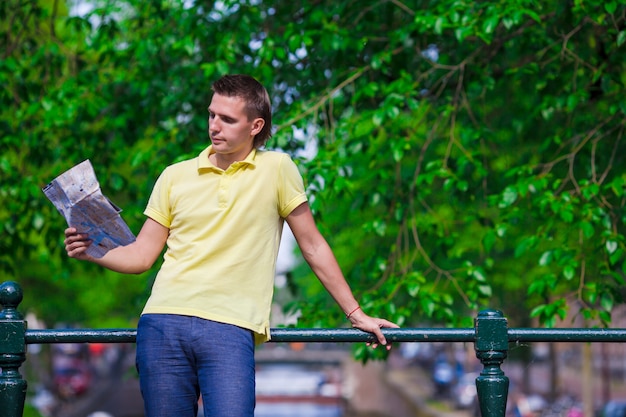 Homme heureux avec une carte de la ville et un sac à dos en Europe