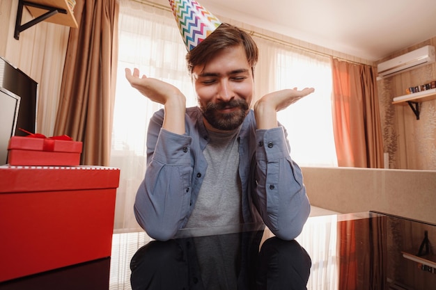 L'homme heureux dans le chapeau de vacances discute avec des amis ou des parents via le chat vidéo