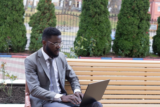 L'homme heureux dans la rue avec un ordinateur portable, à la pige