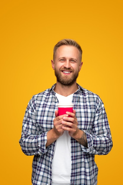 Homme heureux détendu avec une tasse de café à emporter